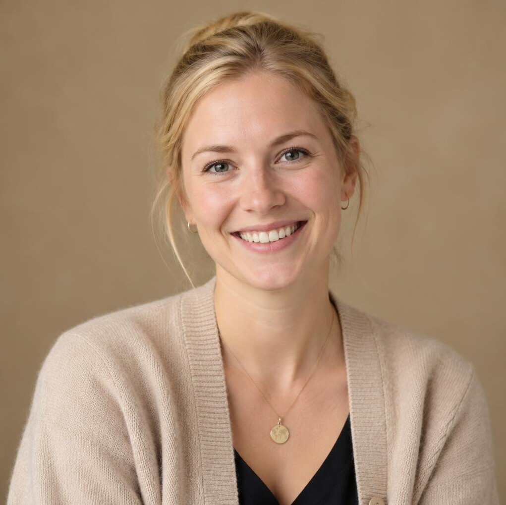 Portrait of a young German woman with blonde hair tied back and a beige cardigan
