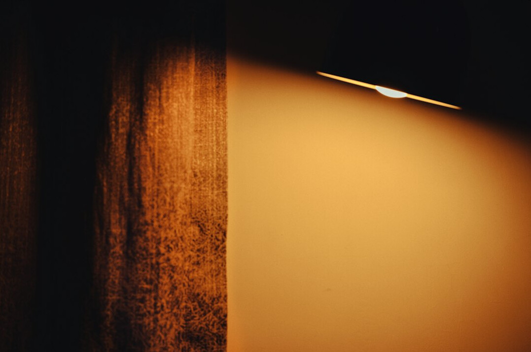 Empty theatre stage with a single spotlight and a dark curtain